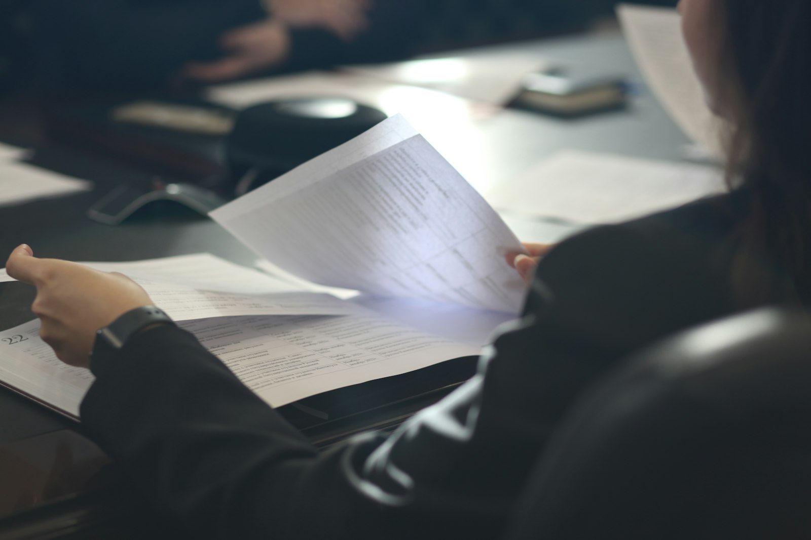 Lecture attentive d'un document dans un bureau, en clair-obscur