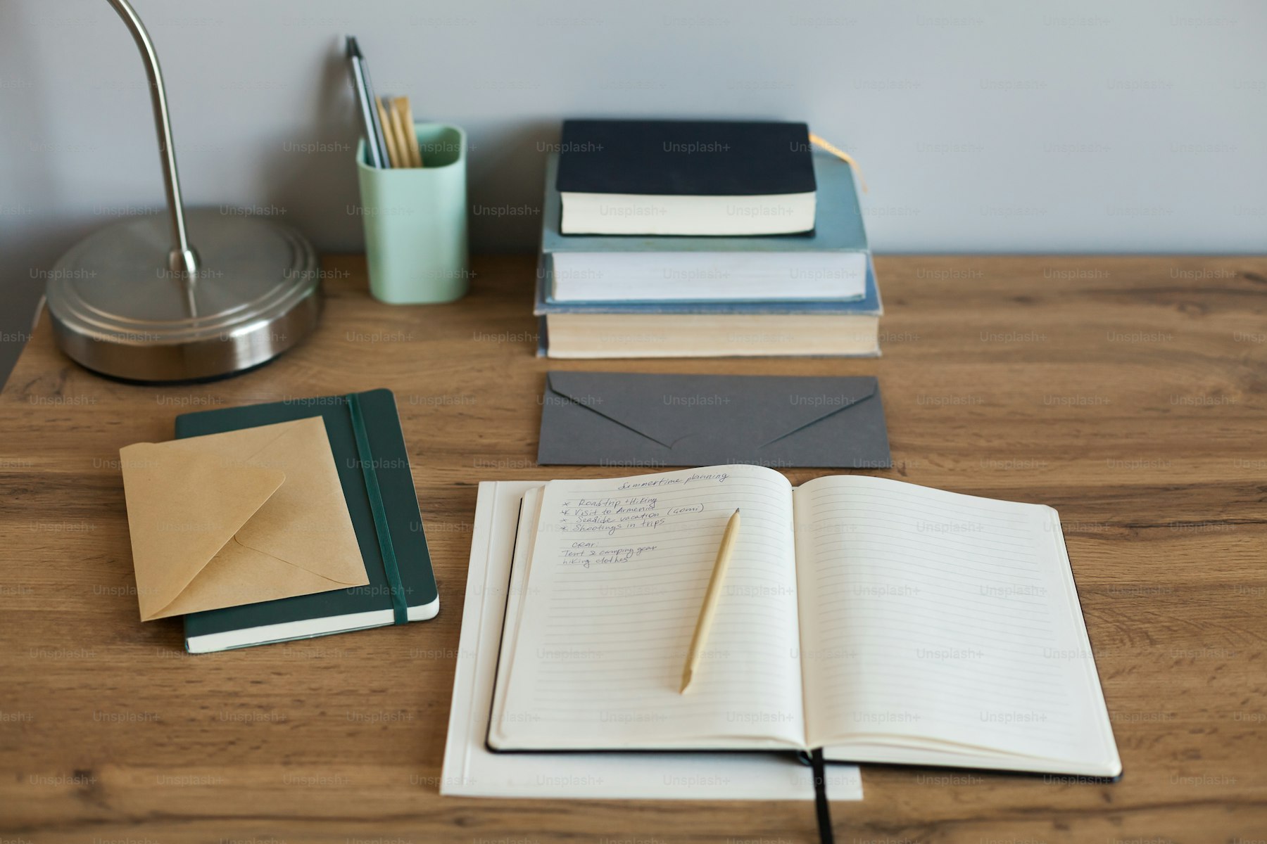 Le décryptage : bureau en bois avec carnets, enveloppes et lampe