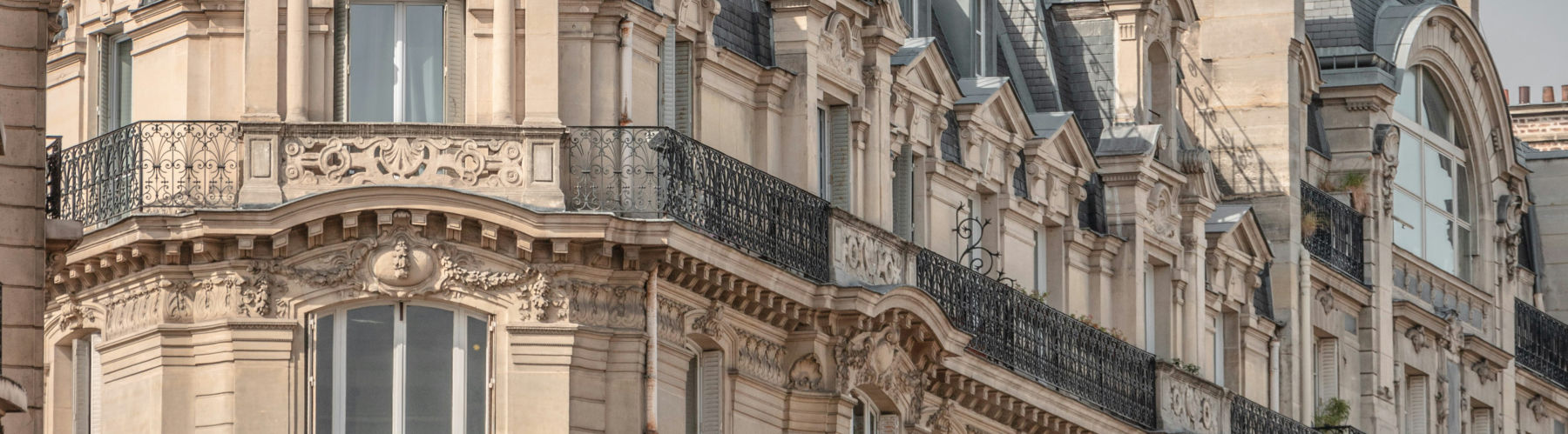 La permanence : façade haussmannienne en pierre de taille et balcons ouvragés