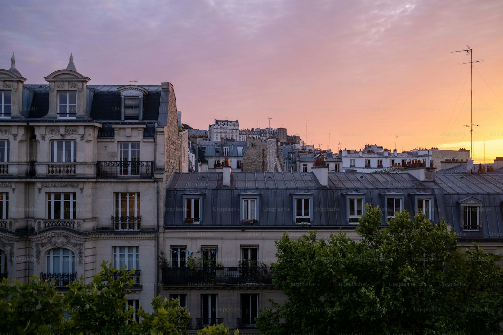 Toits et façades haussmanniennes de Paris sous la lumière dorée du soir